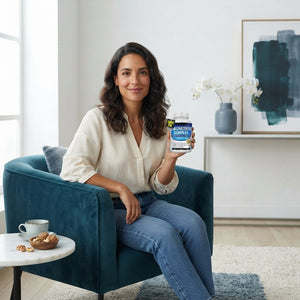 Woman holding a bottle of Zenutraa 8-in-1 Magnesium Complex in a bright, modern living room.